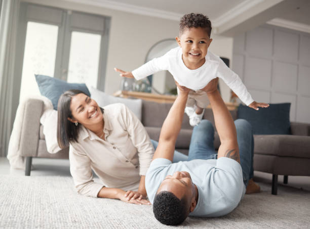 Happy family playing together at home, representing the affluent clients Plumb Bill Pay serves with personalized bill pay and financial management services.